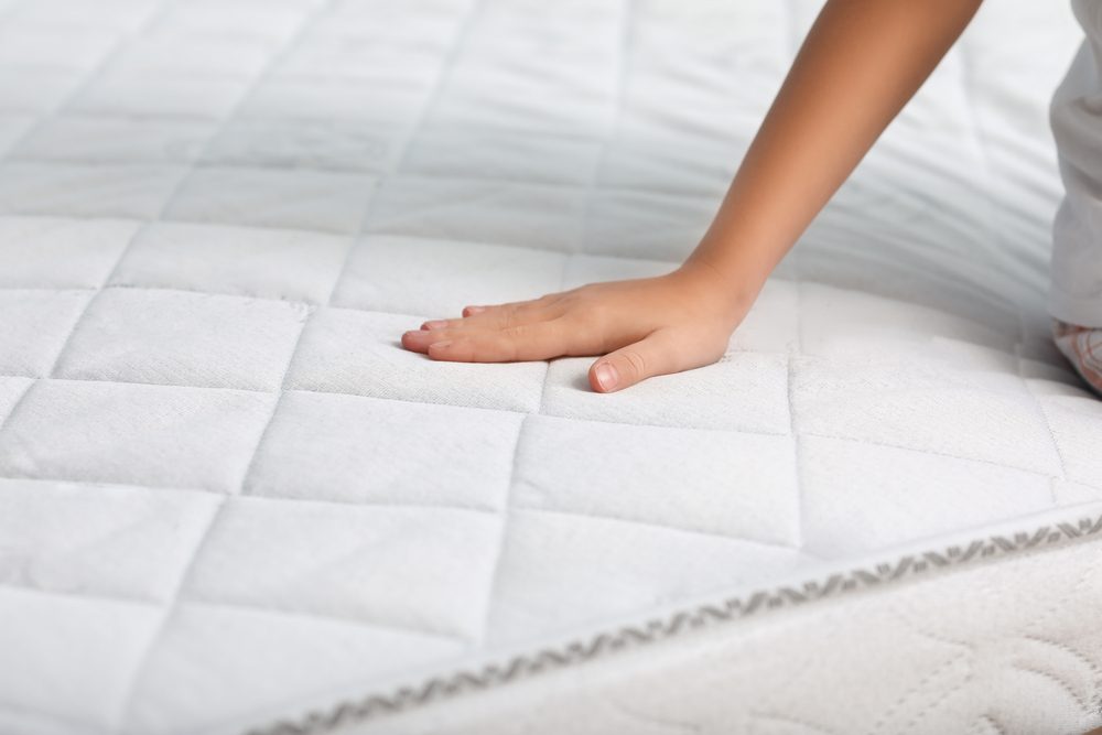 stock photo of a person touching a mattress