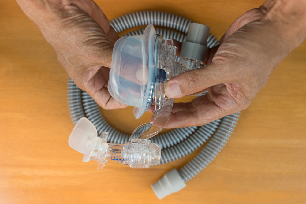 A person holding different parts of a cpap machine