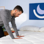 Pressing on mattress as part of testing process.