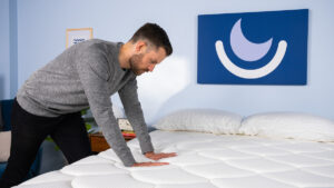 Pressing on mattress as part of testing process.