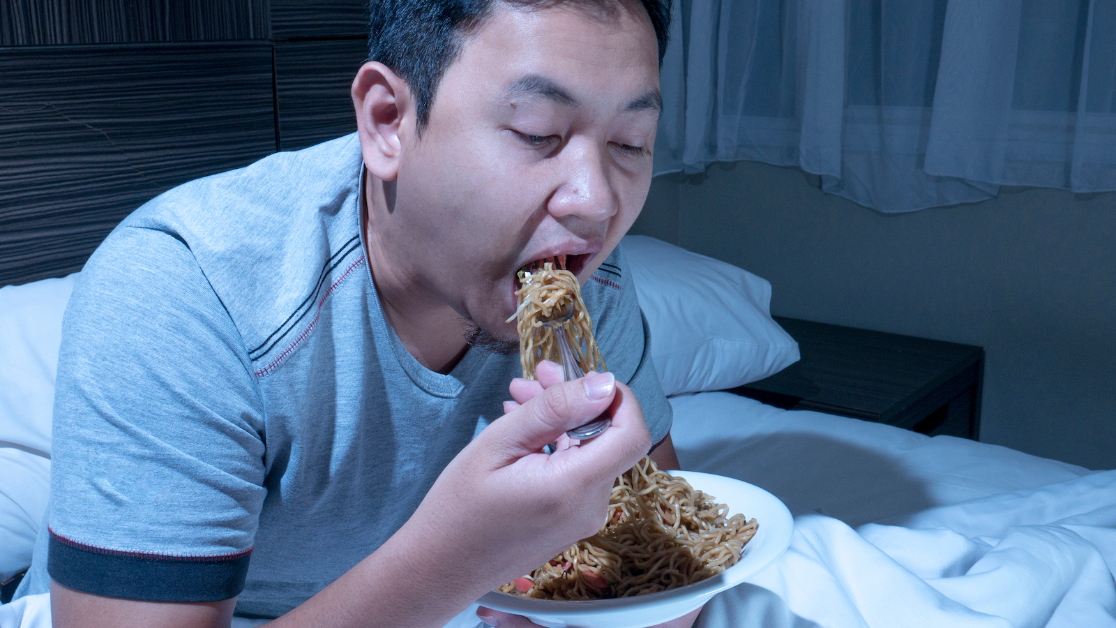 A man eats while partially asleep