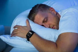Man wearing a device to monitor his sleep